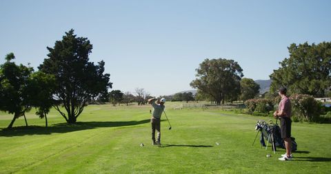 Couple Enjoying a Game of Golf on Sunny Day - Download Free Stock Images Pikwizard.com