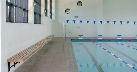 Indoor Swimming Pool with Benches in Modern Facility