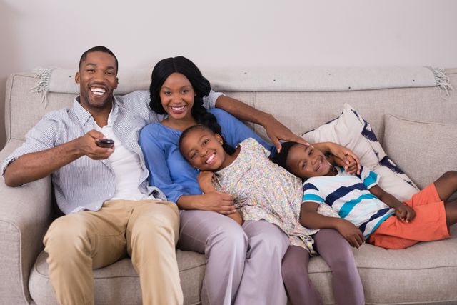 Portrait of happy family enjoying television at home