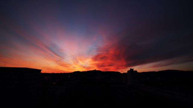 Dramatic city skyline silhouetted against vibrant sunset - Download Free Stock Photos Pikwizard.com