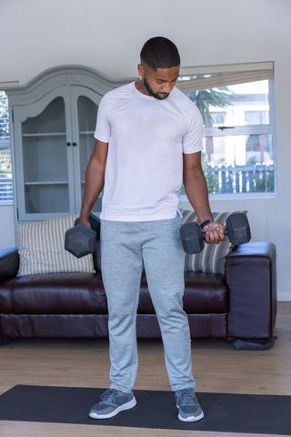 Man Engaging in Dumbbell Workout in Modern Home Living Room