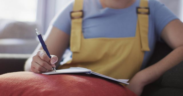 Person Writing Notes in Notebook While Sitting on Couch - Download Free Stock Images Pikwizard.com