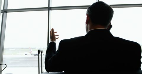 Businessman talking on phone at airport lounge