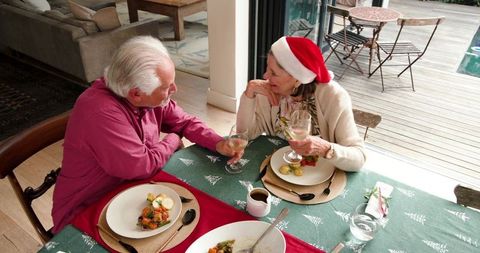 Senior Couple Enjoying Holiday Meal Toasting Wine
