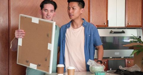 Happy Couple Excitedly Unpacking in New Kitchen