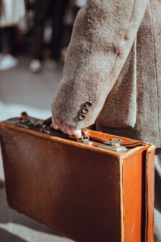 Vintage Suitcase in Hand of Man Wearing Tweed Jacket