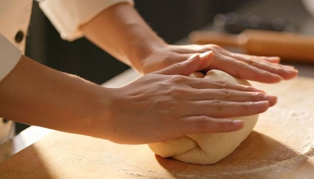 Hands Kneading Dough on Floured Board Closeup Baker Shaping Artisan Bread Preparing Homemade Loaf
