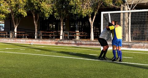 Soccer players celebrating goal at outdoor game