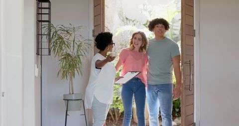 Real estate agent showing young couple modern home