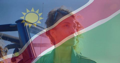 Gazing woman with namibia flag overlay during jeep adventure