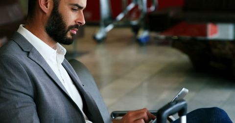 Businessman Using Digital Tablet While Waiting at Airport Lounge