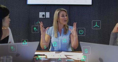 Mature businesswoman leading sustainability strategy meeting with digital icons overlay