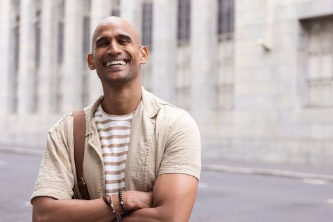 African american man smiling with arms crossed urban casual portrait in daylight