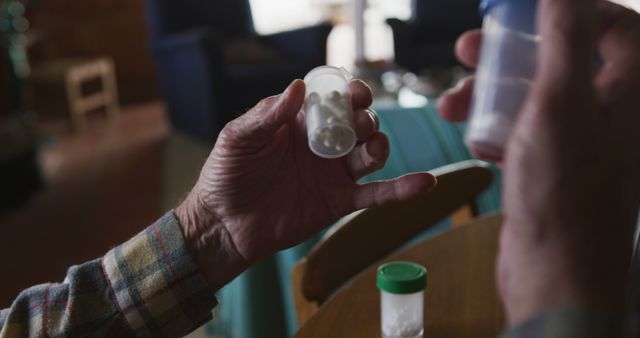 Senior Person Holding Pill Bottles in Domestic Setting - Download Free Stock Images Pikwizard.com