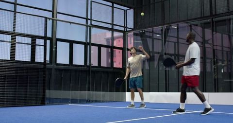 Diverse Friends Enjoying Paddle Tennis Indoors
