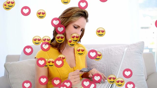 This video depicts a woman holding a credit card while using a laptop surrounded by love emojis. It can be used to illustrate themes of online shopping, digital payments, ecommerce trends, and customer satisfaction in technology and retail-related contexts.