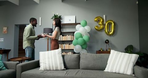 Couple cleaning after birthday part decorations living room