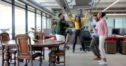Diverse Team Celebrates Success in Bright Modern Office