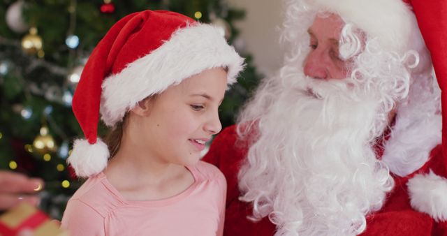 Happy caucasian girl with santa claus talking at christmas. Spending quality time with family at home concept.
