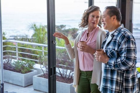 Senior Couple Enjoying Coffee by Ocean View in Modern Home