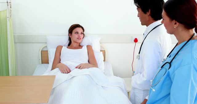 Medical Team Consulting Female Patient in Hospital Bed - Download Free Stock Images Pikwizard.com