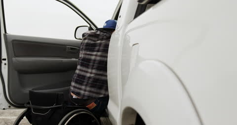 Caucasian Man Transitioning from Wheelchair to Car