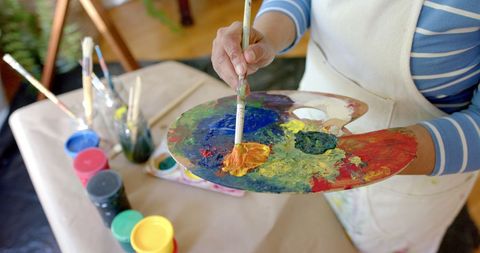 Briacial Woman Painting at Home Mixing Colors on Palette - Download Free Stock Images Pikwizard.com