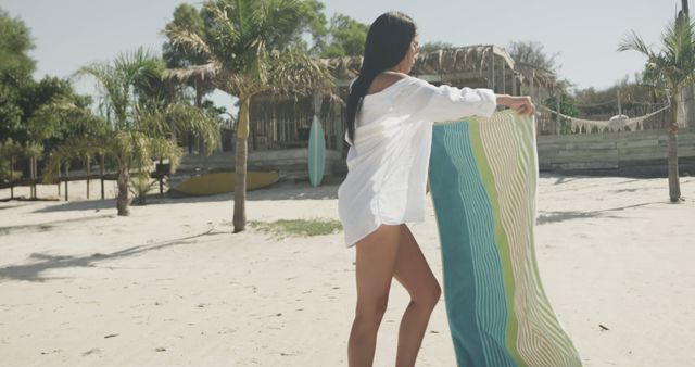 Biracial woman holding towel on beach, copy space - Download Free Stock Photos Pikwizard.com