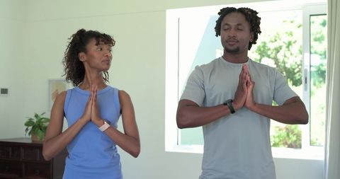 African american couple practicing meditation and mindful fitness at home