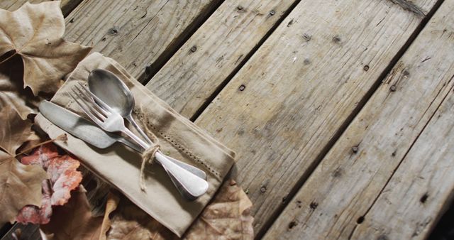 Rustic Table Setting with Silverware and Autumn Leaves on Wooden Surface - Download Free Stock Images Pikwizard.com