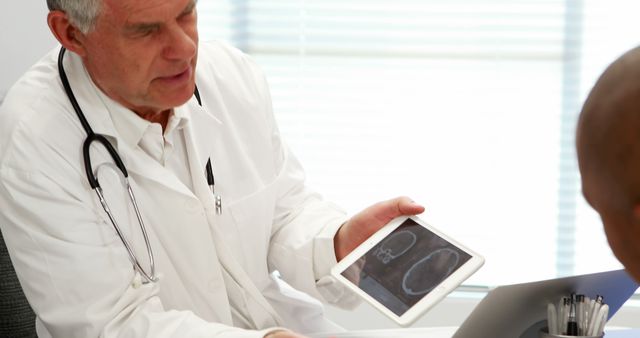 Senior Doctor Discussing Brain Scan Results with Patient Using Tablet - Download Free Stock Images Pikwizard.com
