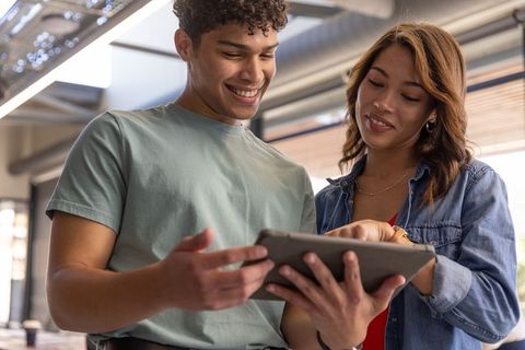Diverse Coworkers Collaborating on Tablet in Modern Office