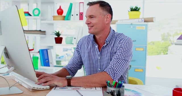 Smiling Professional Man Working on Computer in Creative Office - Download Free Stock Images Pikwizard.com