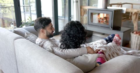 Couple Relaxing by Fireplace Sharing Cozy Moments at Home