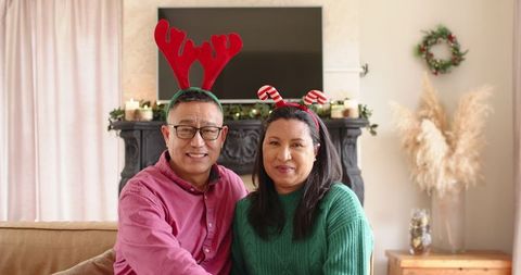 Senior couple in festive headbands enjoying cozy hopliday atmosphere