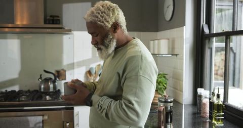 Mature Man Preparing Spices in Modern Kitchen