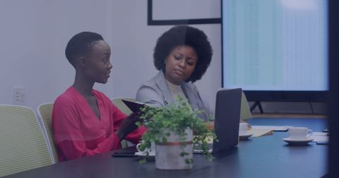 Diverse Colleagues Discussing Work at Conference Table with Technology