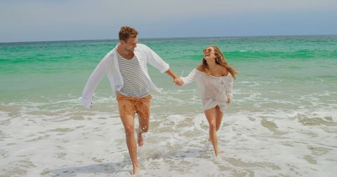 Joyful Couple Running on Sunny Beach Day - Download Free Stock Images Pikwizard.com