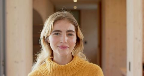 Stylish woman in modern wooden interior wearing knit sweater