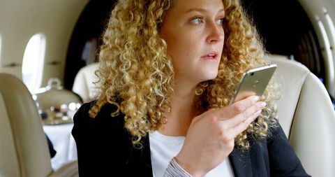 Businesswoman calling while traveling on private jet