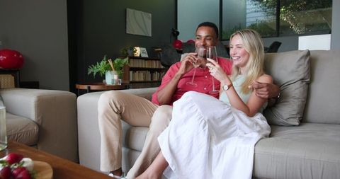 Couple Celebrating at Home with Champagne in Living Room