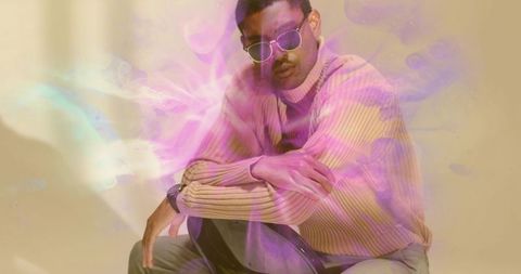 Fashion model with sunglasses sitting in luminous studio