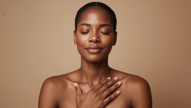 Serene black woman resting hand on heart shoulders practicing self care wellness portrait