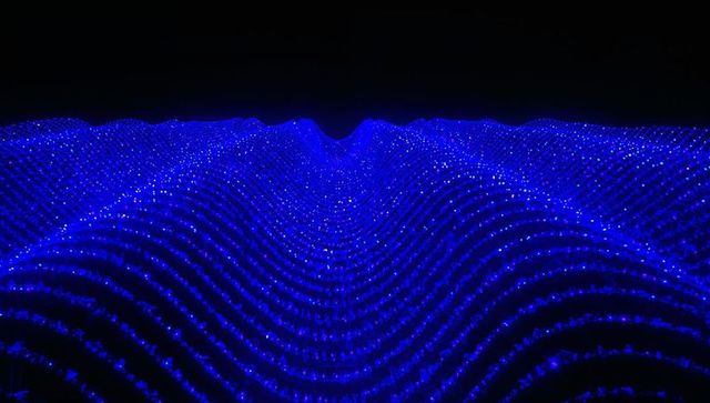 Glowing cobalt led wavefield featuring undulating point light grid and neon luminescence