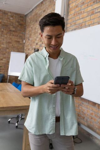 Asian professional communicating via smartphone in modern office