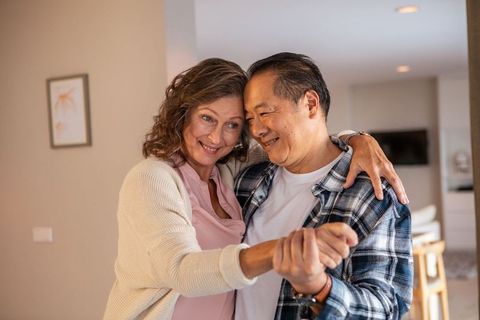 Happy Senior Couple Dancing Together in Cozy Living Room