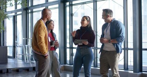 Diverse Team Collaborating in Modern Office Lobby During Networking Break