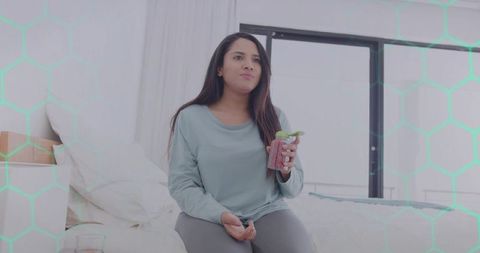 Woman Relaxing with Mint Smoothie in Minimalist Bedroom Setting