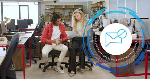 Young professionals collaborating over documents in coworking office with digital mail icon