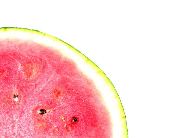 Close-up of a fresh watermelon slice featuring vibrant red flesh and green rind placed on a white background. Suitable for use in health and wellness articles, summer-themed promotions, fruit displays, and food blogs. Illustrates attributes like freshness, tropical taste, and a healthy lifestyle.